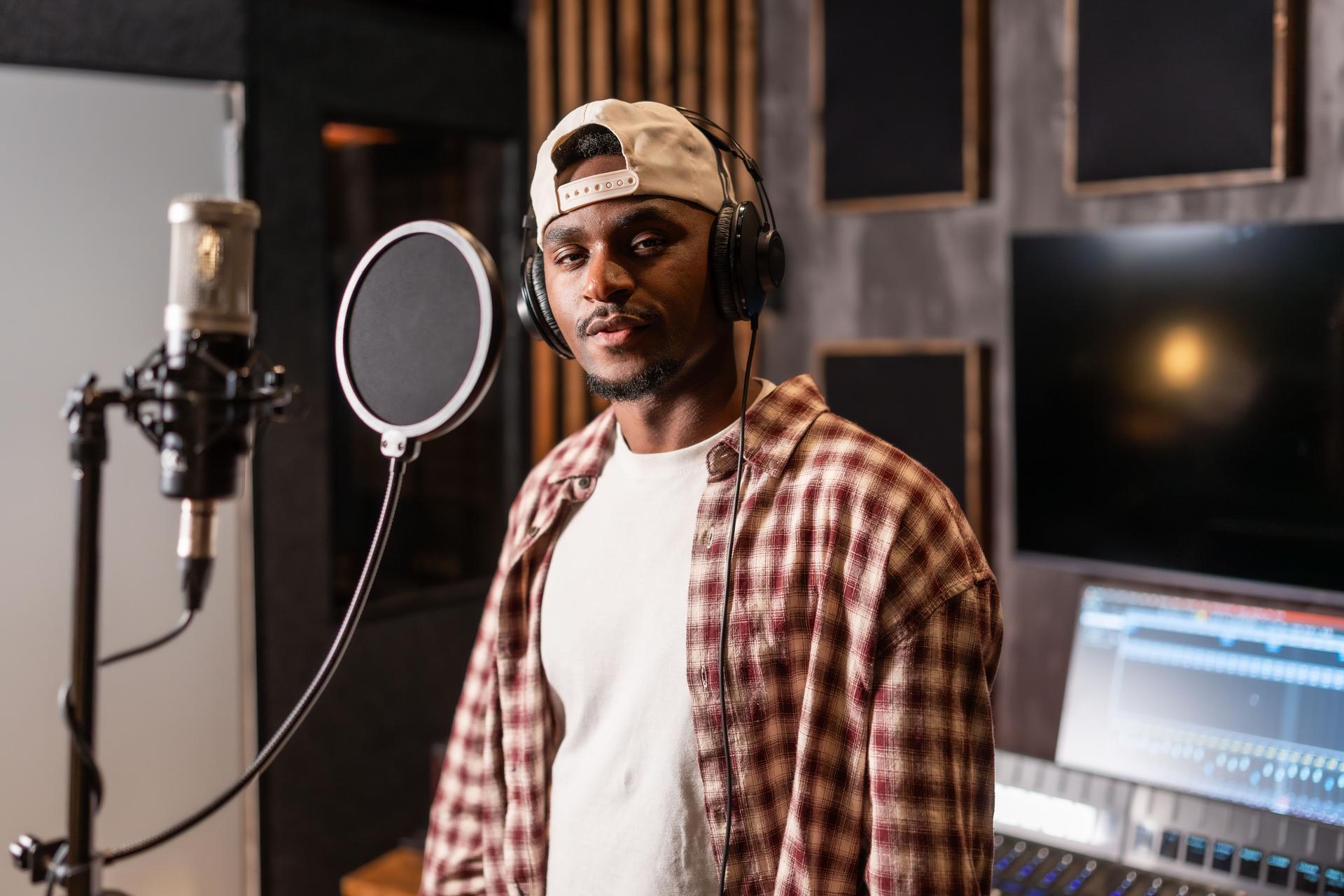 Young african american artist recording music in professional studio
