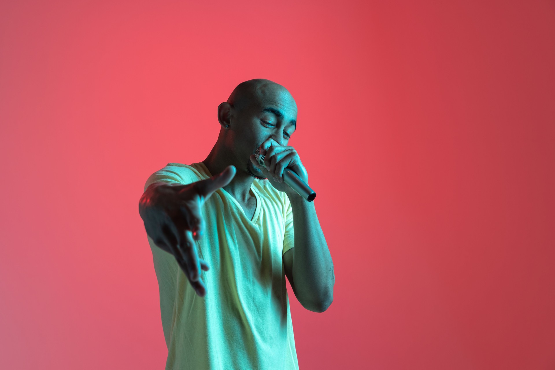 African-american young man's portrait on red studio background in neon. Concept of human emotions, facial expression, youth, sales, ad.